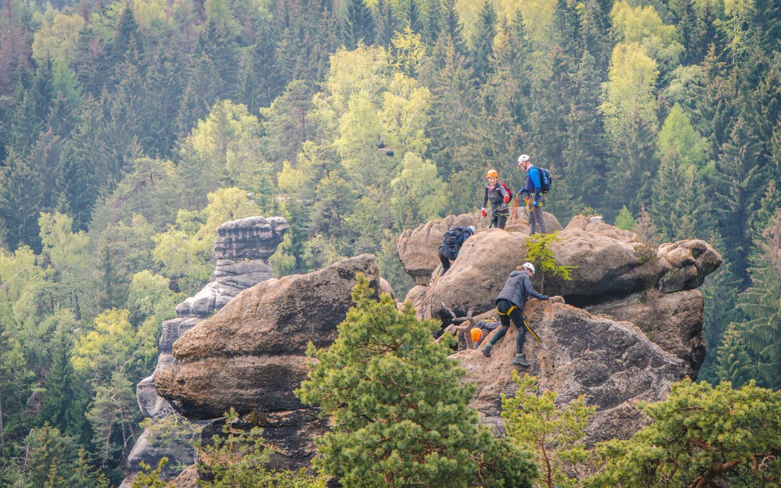 Grupa osób stoi na szczycie skały