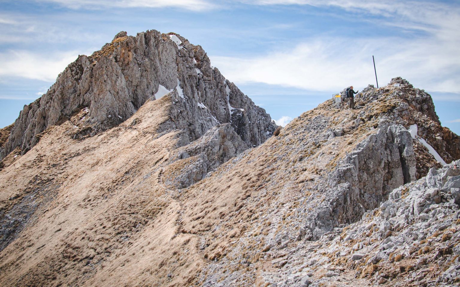 Mężczyzna stoi na wzniesieniu ponad przełęczą w Karawankach