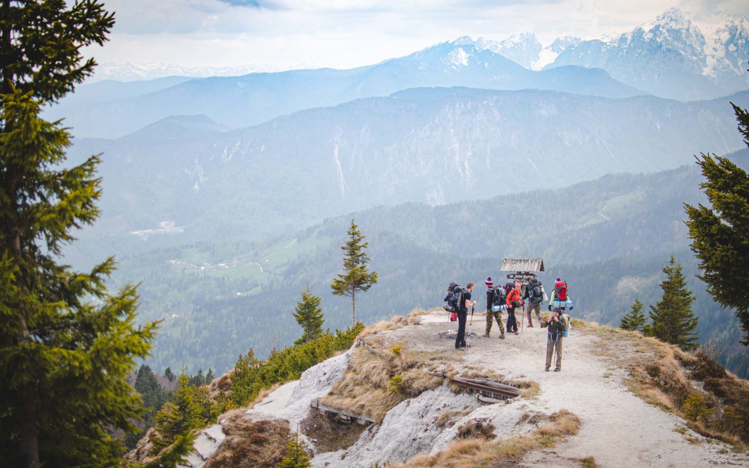 Grupa osób stoi na szlaku w górach
