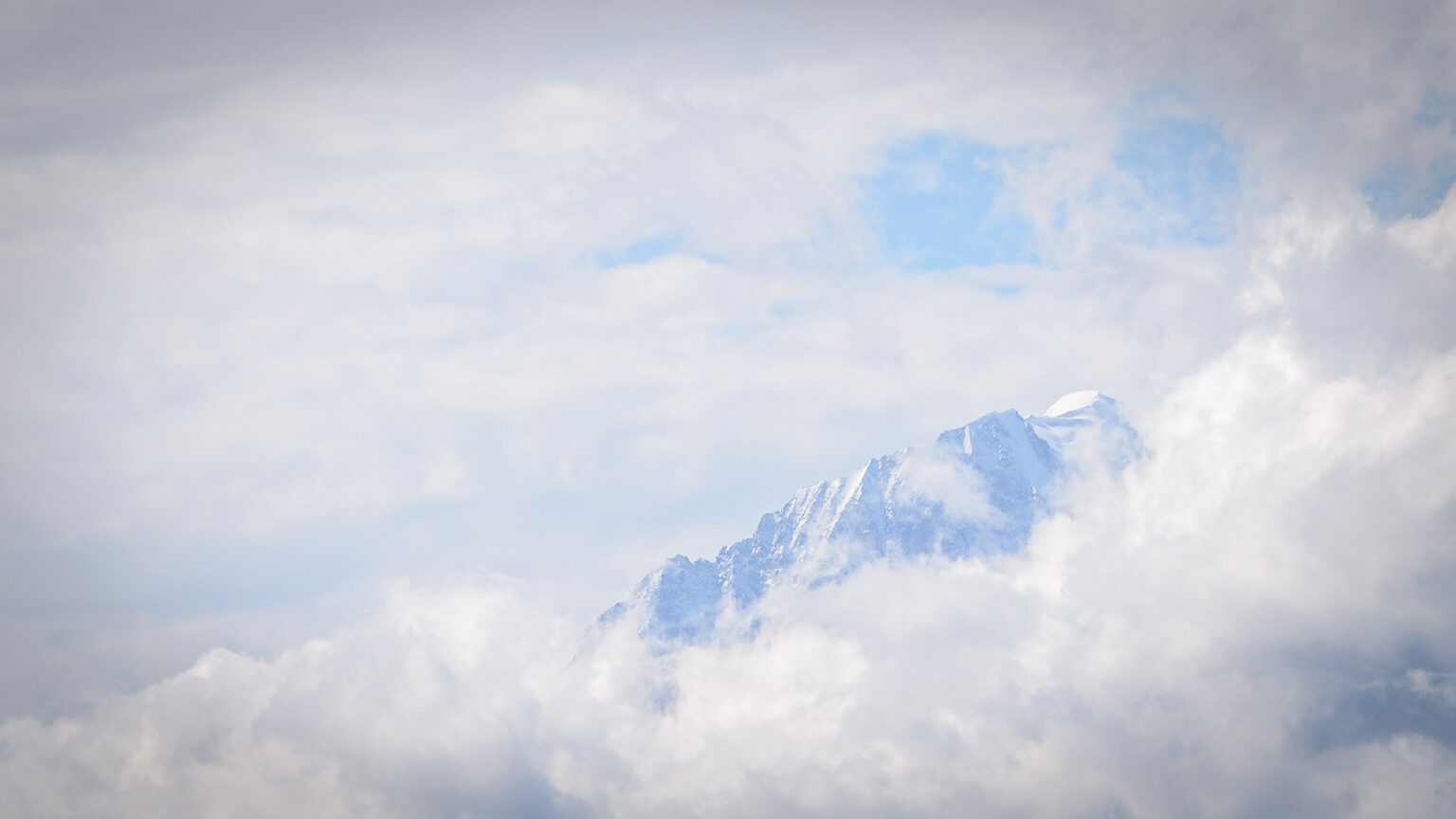 Wierzchołek Mont Blanc i masyw w chmurach