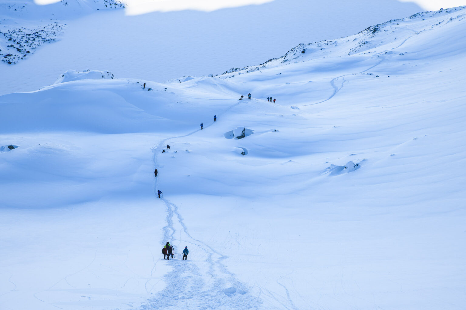 Turyści wędrujący wąską ścieżką na śniegu prowadząca na Szpiglasowy Wierch zimą