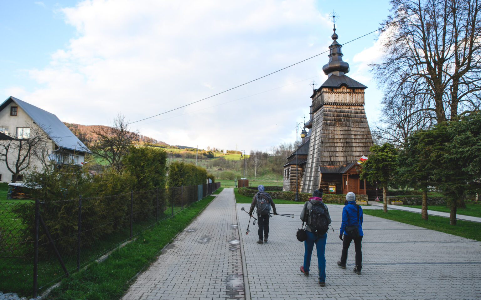 Turyści przechodzący obok cerkwi w Szczanwniku